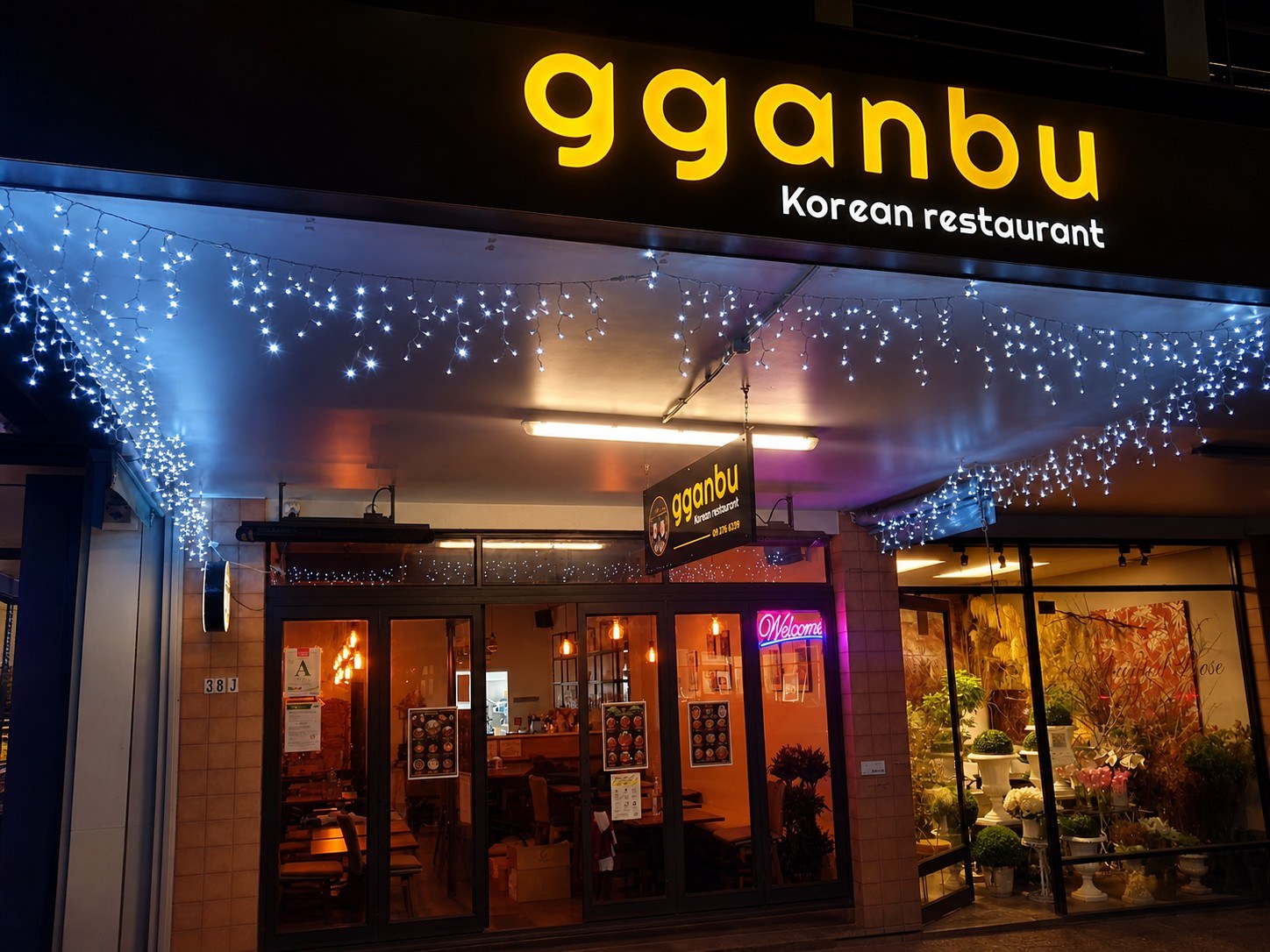 Gganbu Korean Restaurant storefront on Jervois Road in Ponsonby with illuminated sign, fairy lights and welcome neon